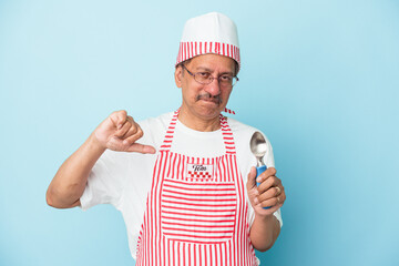 Senior indian ice cream man holding a scoop isolated on blue background showing a dislike gesture, thumbs down. Disagreement concept.