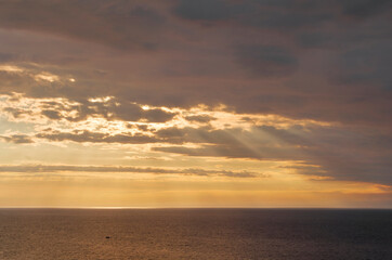 Fototapeta na wymiar Beautiful summer sunset over the baltic sea. The sun rays pass through the clouds