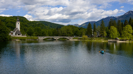 Aerial bird eye shot of a canoe with two person paddling, on beautiful turquoise lake water