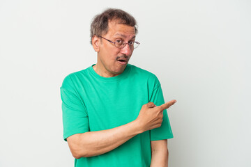 Middle aged indian man isolated on white background smiling and pointing aside, showing something at blank space.