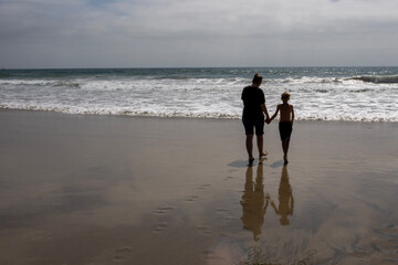 Mother and child walking on beach