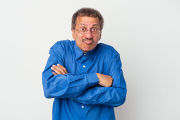 Middle aged indian man isolated on white background shrugs shoulders and open eyes confused.