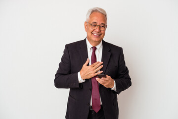 Senior business american man holding mobile phone isolated on white background laughs out loudly keeping hand on chest.