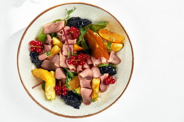 Duck breast salad, Cold smoked duck breast in salad with oranges and apples and red berries, white background, top view, copy space