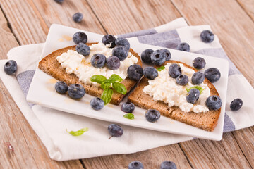 Rye bread with cottage cheese, blueberries and honey.