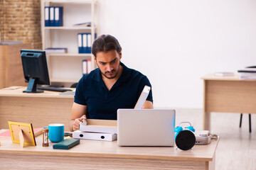Young male employee ordering pizza at workplace