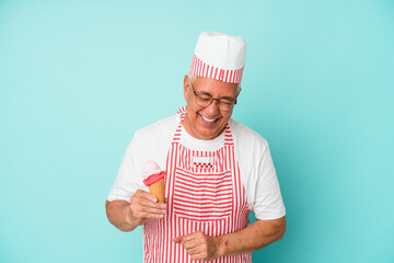 Senior american ice cream maker holding an ice cream isolated on blue background laughing and having fun.