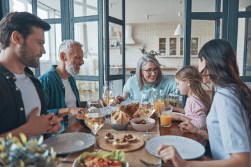 Fototapeta na wymiar Happy multi-generation family smiling while having dinner together