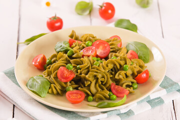 Fusilli pasta with cherry tomatoes and peas.