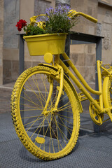 Gelbes Fahrrad mit Blumen am Lenker