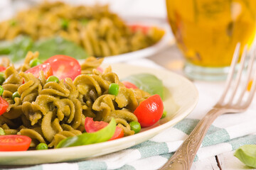 Fusilli pasta with cherry tomatoes and peas.