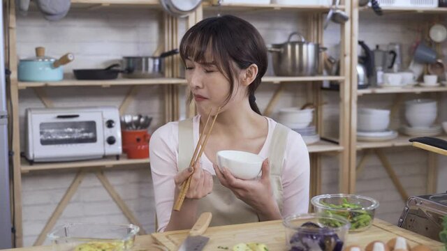 Housewife Trying A Piece Of Vegetable Is Showing A Disgusting Look As It's Too Salty And Touching Nose Feeling Bad About Her Failure In The Kitchen.