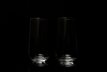 Two empty glasses for wine in a dark studio environment