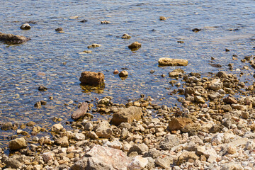 Stones on the shore of the warm tropical sea in Crete.