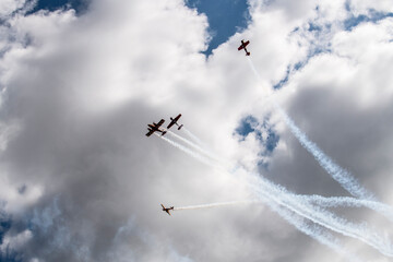 a beautiful plane makes a difficult turn leaves a white trail of flight against the background of the sky