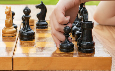 grandfather and grandson play chess in the village