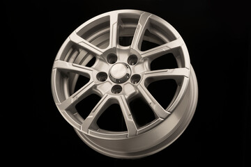 grey new alloy wheel for car, side view on black background
