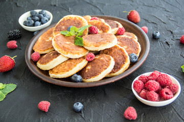A healthy breakfast of cheese pancakes, berries, and honey. Creative atmospheric decoration
