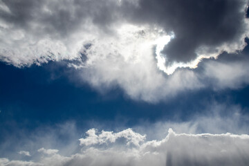 Obraz premium Clouds with silver lining - dark cloud lined with white in dark blue sky with tumultous clouds surrounding
