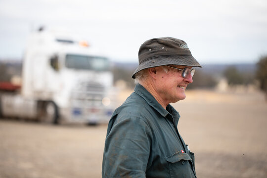 Older Man In Workwear Outdoors With Prime Mover In Background