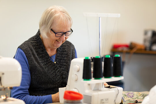 mature lady sewing with overlocking machine