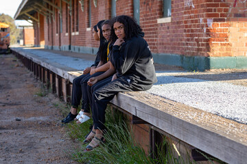 four teen girls sitting on disused railway platform