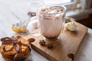 Hot drink with marshmallows on a wooden table.