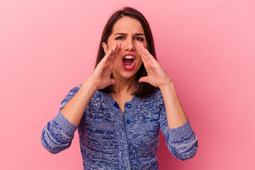 Young caucasian woman isolated on pink background shouting excited to front.