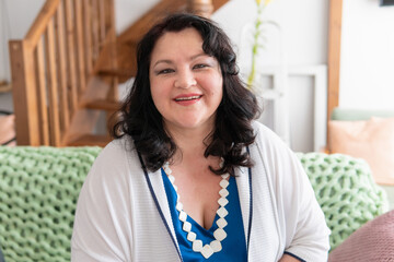 A woman is sitting on a sofa in a room in the house.