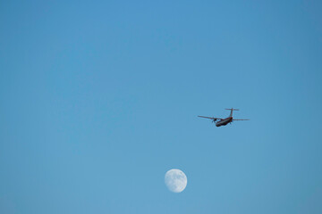 Avión despegando bajo la luna.