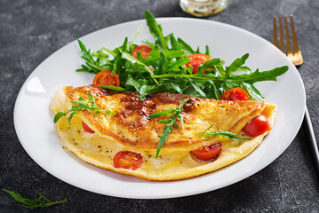 Breakfast. Omelette with tomatoes, cheese  and salad on white plate.  Frittata - italian omelet.