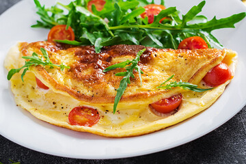 Breakfast. Omelette with tomatoes, cheese  and salad on white plate.  Frittata - italian omelet.
