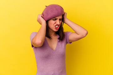 Naklejka premium Young caucasian woman isolated on yellow background covering ears with hands.