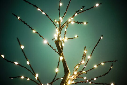 LED-Lampenbaum vor einem gr&uuml;nen Hintergrund. Leuchtende funkelnde &Auml;ste mit vielen Verzweigungen.