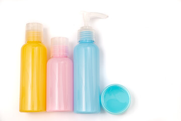 jars with blue, pink and yellow cosmetics on white background