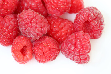 Red raspberry on white background. Ripe berries close up, summer crop