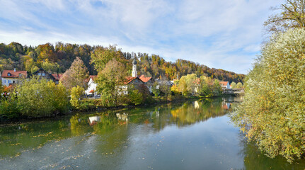 Fototapeta na wymiar Loisach river Wolfratshausen, view to church and village, autumnal scenery bavaria