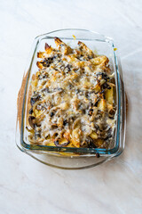 Baked Potatoes with Mushrooms and Parmesan Cheese Casserole in Glass Bowl.