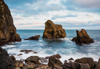Icelandic wild coast with large rocks on the beach