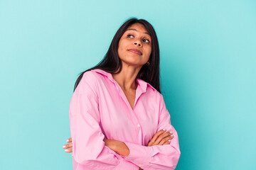 Fototapeta premium Young latin woman isolated on blue background dreaming of achieving goals and purposes