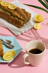 lemon poppy cupcake on a blue minimalistic plate on a pink background. Composition with hard shadows from the sun
