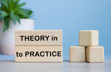 THEORY IN TO PRACTICE word on wooden cubes on white desk.