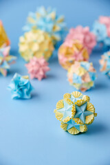 Set of multicolor handmade modular origami balls or Kusudama Isolated on blue background. Visual...