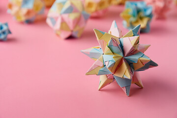 Set of multicolor handmade modular origami balls or Kusudama Isolated on pink background. Visual...
