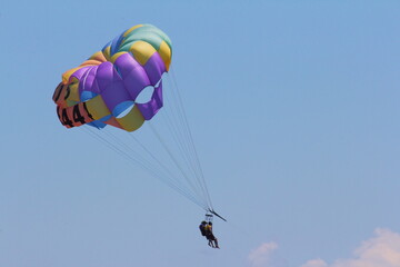 Naklejka na ściany i meble Parachute on the beach flying in the sky