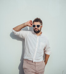 Handsome beard man posing in the street, near with wall, sunglasses, hipster style, outdoor portrait, fashion model, happy face, 