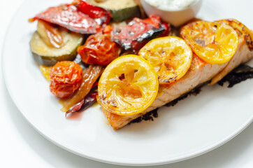 Grilled salmon fillet served with roasted vegetables with cucumber and dill sauce