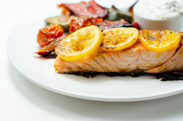 Grilled salmon fillet served with roasted vegetables with cucumber and dill sauce