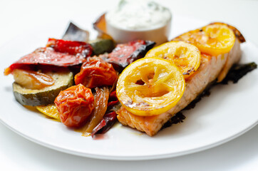 Grilled salmon fillet served with roasted vegetables with cucumber and dill sauce