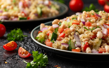 Quinoa white bean salad with cherry tomatoes, cucumber, red onion and herbs. Healthy vegan food